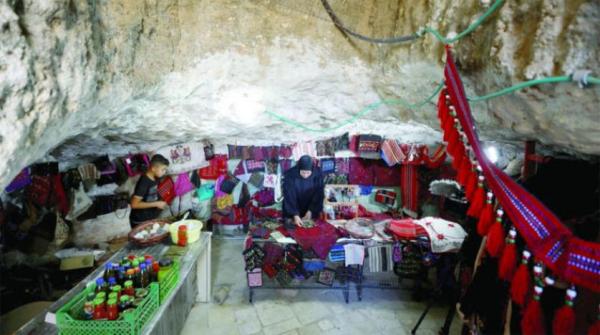 نساء قرية فلسطينية يعرضن التراث داخل كهف