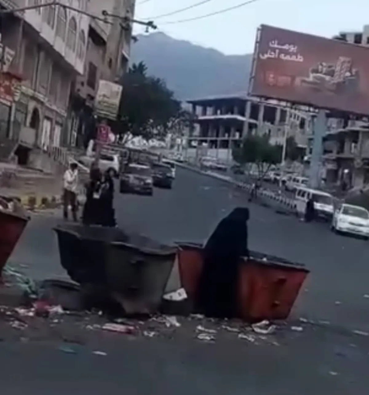 بتعز.. امرأة تفتش في براميل القمامة بحثاً عن الطعام
